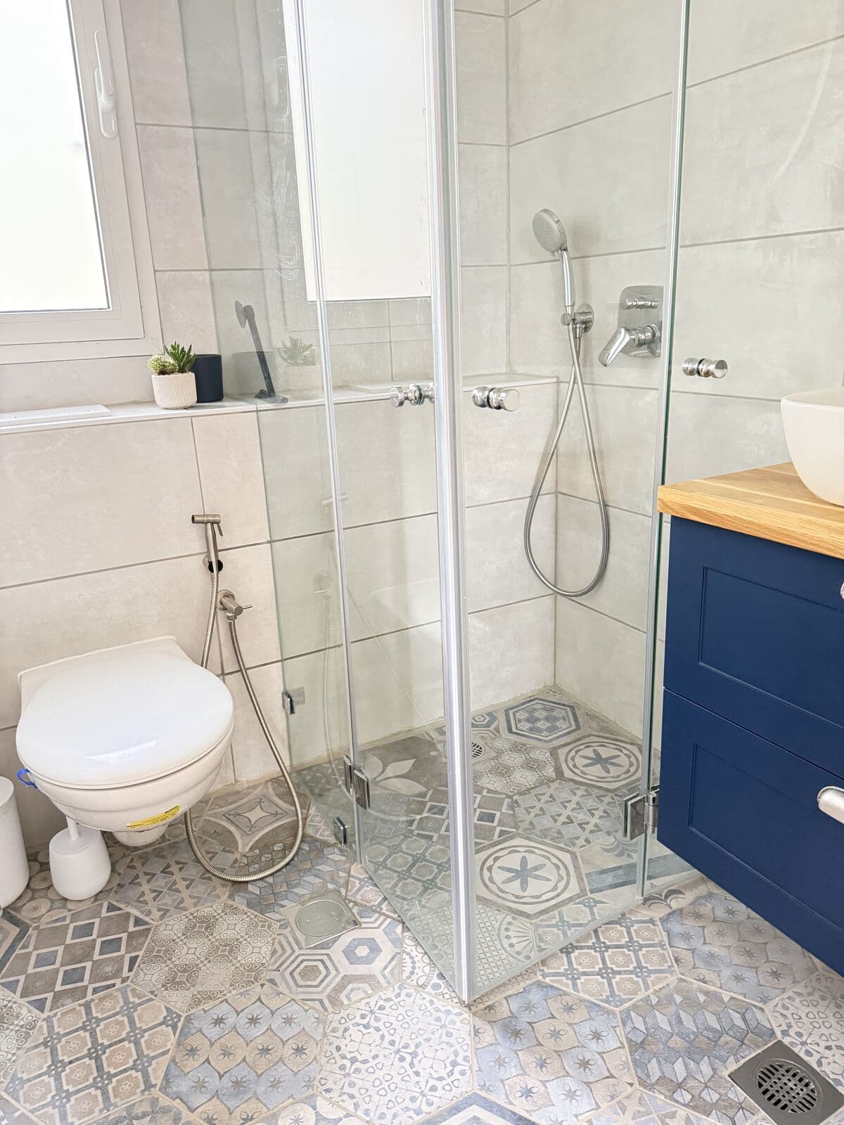 The studio bathroom features a glass-enclosed shower
