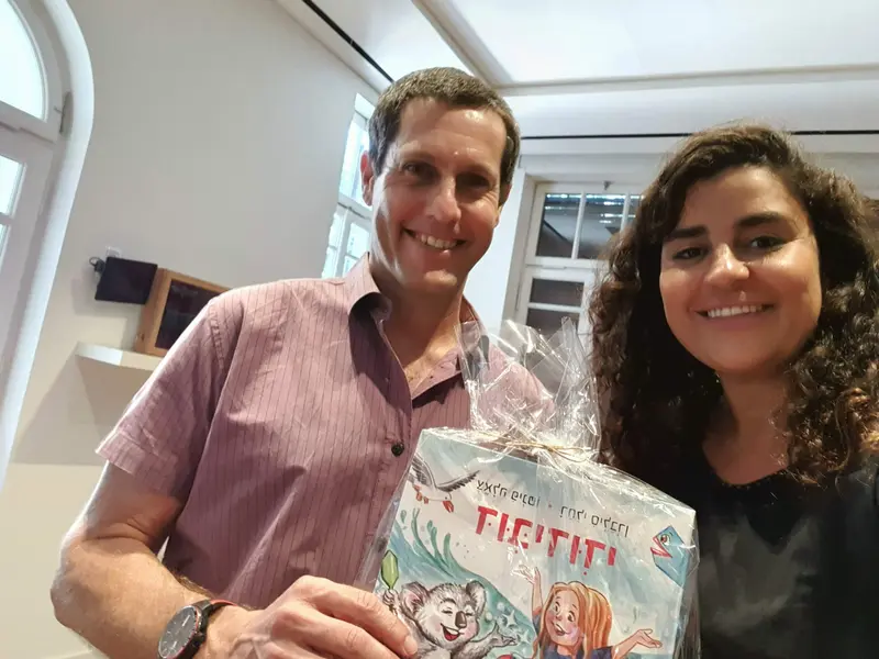 גבר ואישה מחייכים מחזיקים את הספר דובידודי